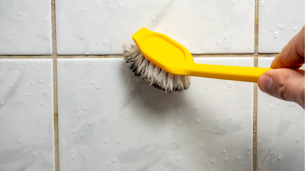 removing mold from shower with a brush