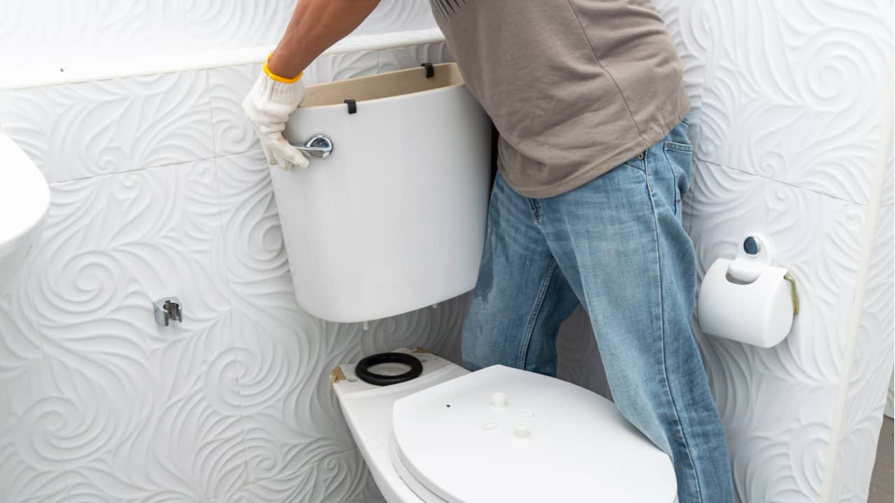 Man removing a toilet tank